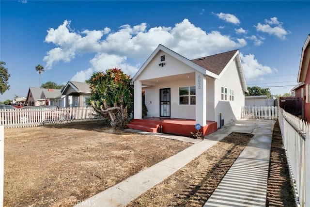 6050 Madden Ave, Los Angeles, CA 90043 - bungalow-style home with roof with shingles, stucco siding, a fenced backyard, and covered porch