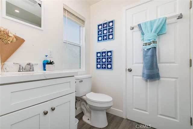 bathroom with vanity, wood-type flooring, and toilet