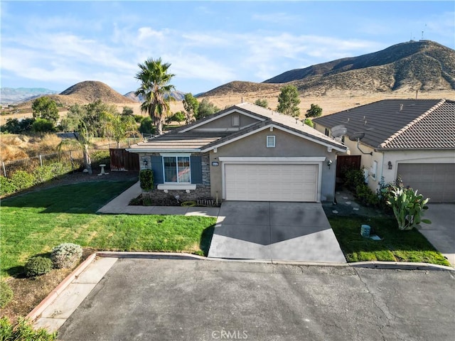 ranch-style house with a mountain view, a front lawn, and a garage