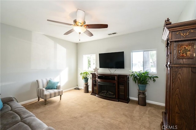 carpeted living room with ceiling fan and a healthy amount of sunlight