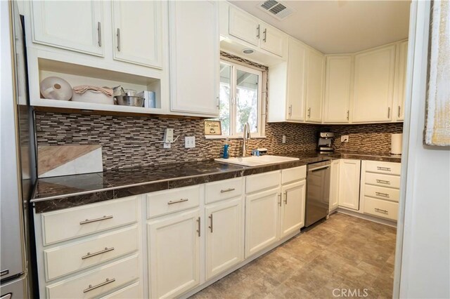 kitchen featuring tasteful backsplash, dishwasher, sink, and white cabinets