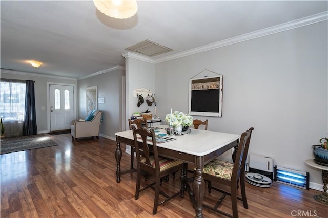 dining room with a baseboard radiator, crown molding, baseboards, and wood finished floors