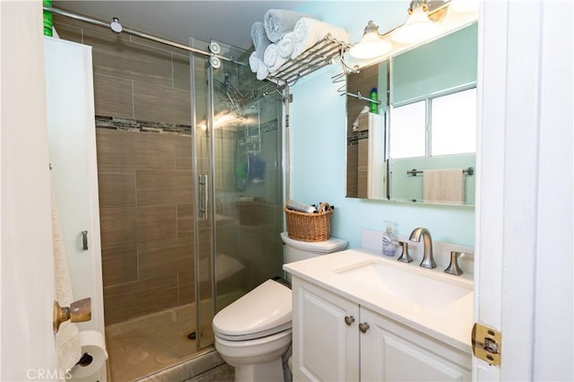 bathroom with vanity, toilet, and a shower with shower door