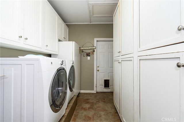 clothes washing area with washing machine and clothes dryer, crown molding, and cabinets