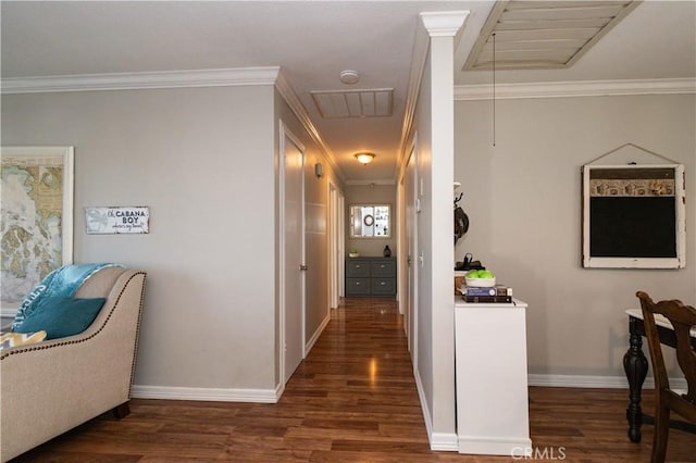 hall featuring wood finished floors, visible vents, baseboards, attic access, and crown molding