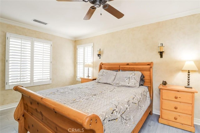 bedroom featuring light wood-type flooring, ceiling fan, and crown molding