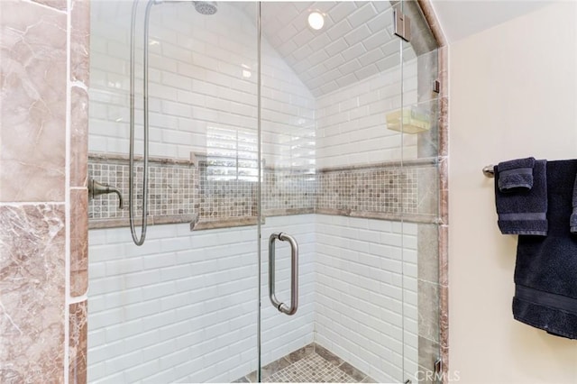 bathroom featuring vaulted ceiling and a shower with door