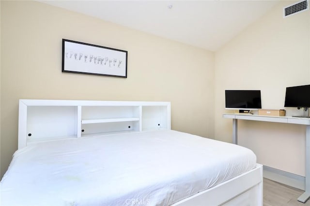 bedroom featuring light hardwood / wood-style floors and vaulted ceiling