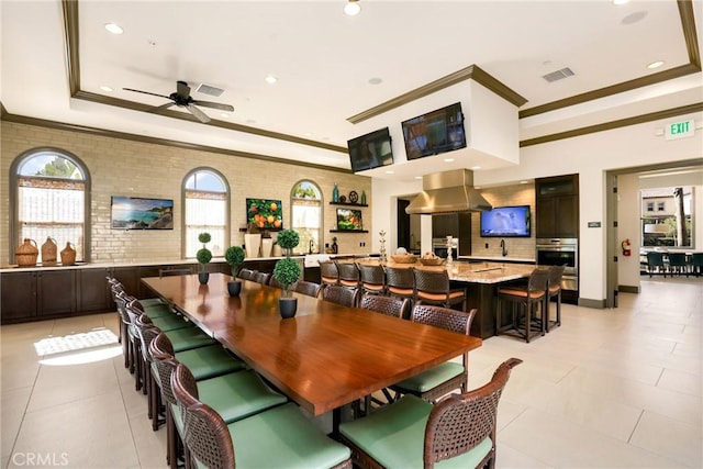 tiled dining room featuring a raised ceiling and ceiling fan