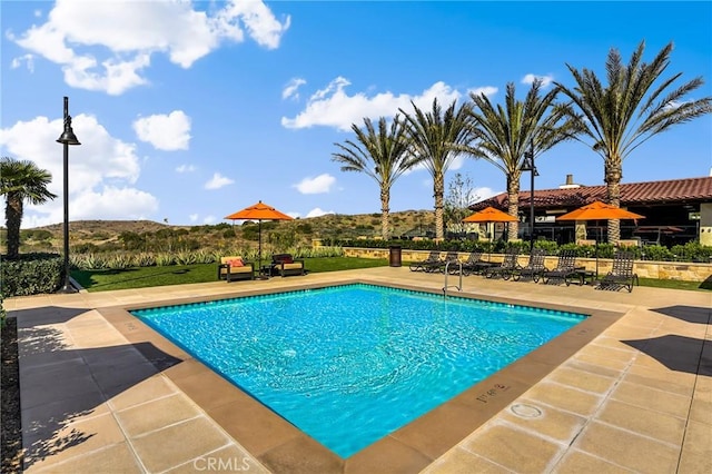 view of swimming pool with a patio area and a mountain view