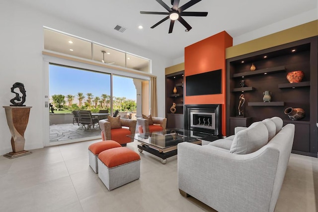 living room featuring built in shelves and ceiling fan