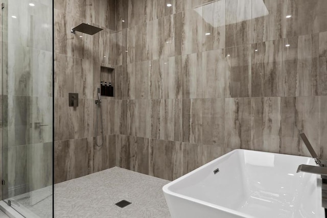 bathroom featuring shower with separate bathtub, tile walls, and sink