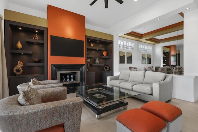 living room with built in shelves and ceiling fan