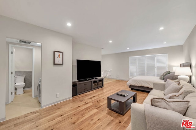 bedroom featuring ensuite bathroom and light hardwood / wood-style floors