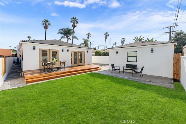 back of house with a lawn, a deck, and french doors