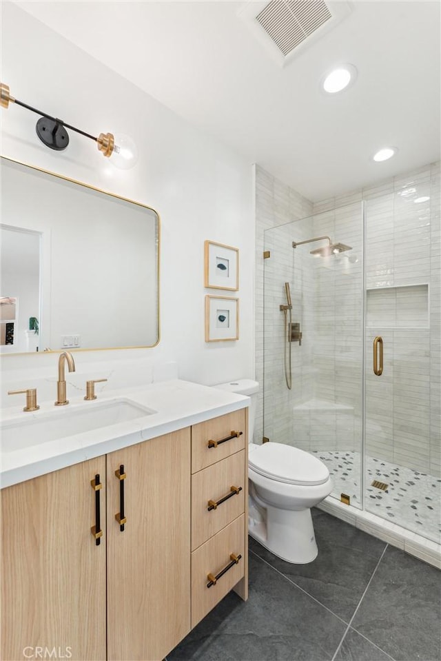 bathroom featuring tile patterned floors, vanity, an enclosed shower, and toilet