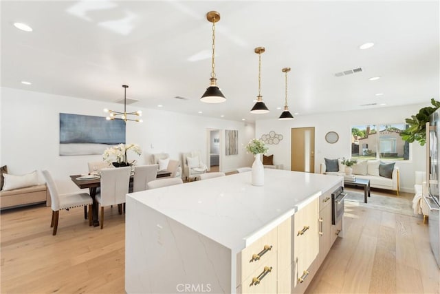 kitchen with pendant lighting, light hardwood / wood-style floors, and a kitchen island