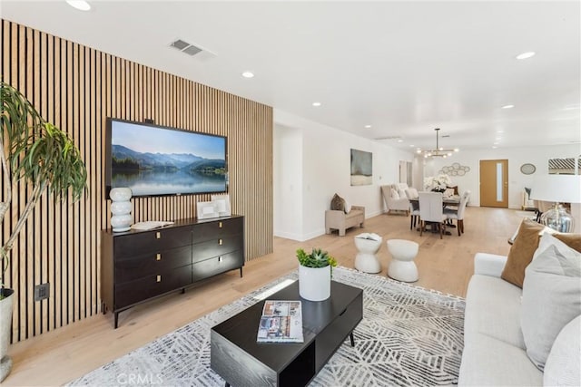 living room with a notable chandelier and light hardwood / wood-style floors