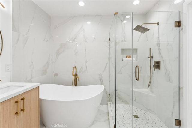 bathroom featuring vanity, tile walls, and shower with separate bathtub