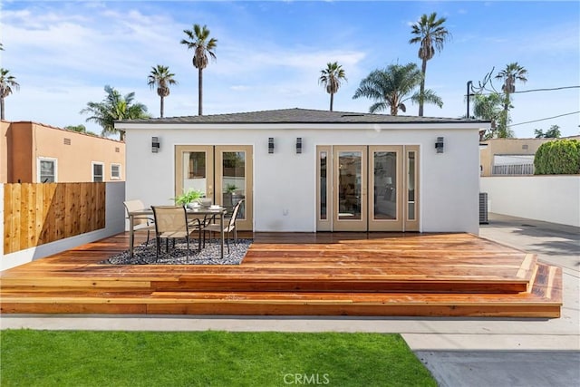 rear view of house featuring a wooden deck and french doors