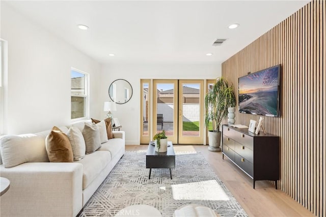 living room with french doors and light wood-type flooring