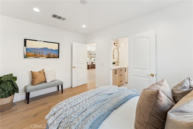 bedroom featuring light wood-type flooring and connected bathroom