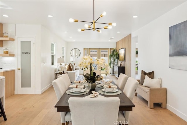 dining area with an inviting chandelier and light wood-type flooring