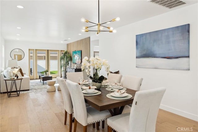 dining room featuring light hardwood / wood-style flooring and a notable chandelier