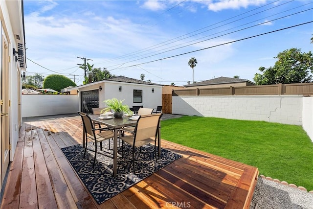 deck with an outbuilding, a garage, and a lawn