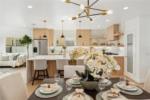 dining space featuring a notable chandelier and light wood-type flooring