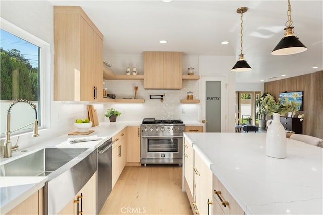 kitchen featuring pendant lighting, light stone countertops, stainless steel appliances, and light brown cabinetry