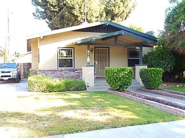 view of front of house featuring covered porch and a front lawn