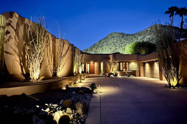 pueblo-style house with a garage and a mountain view