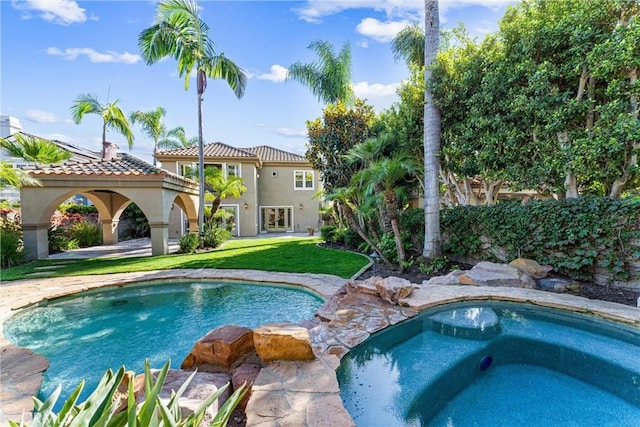 view of pool featuring an in ground hot tub and a lawn