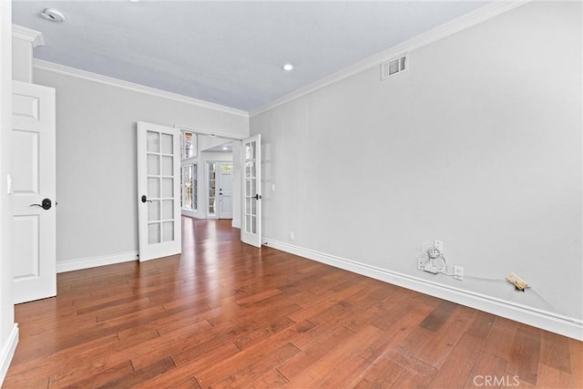 spare room with wood-type flooring, crown molding, and french doors