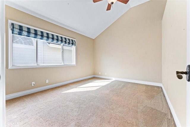 carpeted spare room with ceiling fan and vaulted ceiling