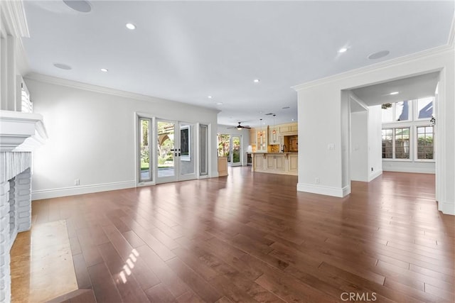 unfurnished living room with ceiling fan, dark hardwood / wood-style floors, ornamental molding, and a fireplace