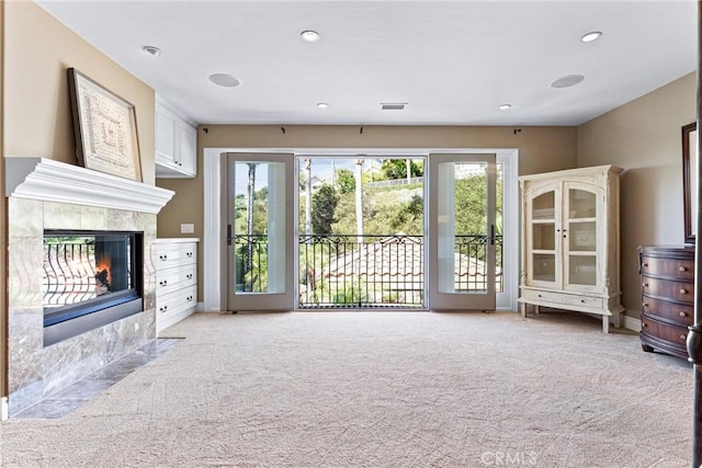 unfurnished living room featuring light colored carpet and a fireplace