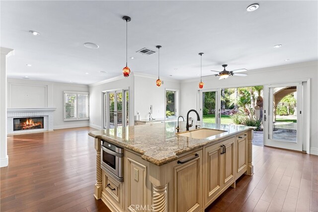 kitchen with a center island with sink, ceiling fan, french doors, pendant lighting, and sink