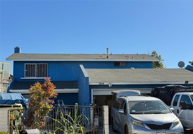 view of front of home featuring a garage, driveway, and fence