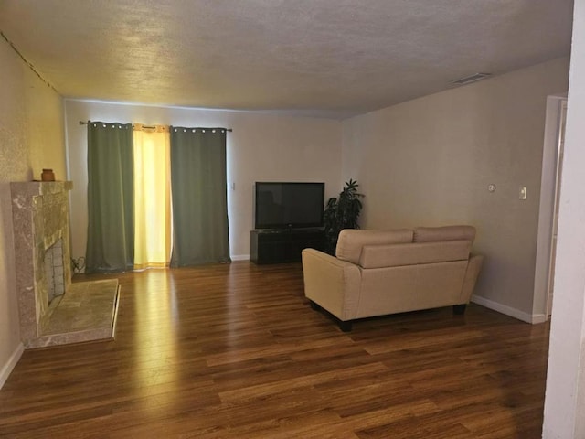 living room featuring dark wood-type flooring and a textured ceiling