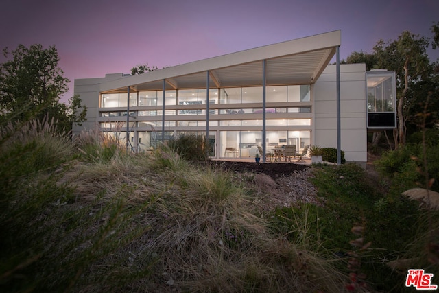 view of back house at dusk