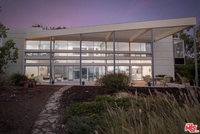 back house at dusk with a patio