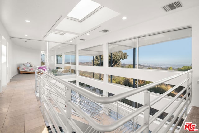 interior space with a skylight and tile patterned flooring