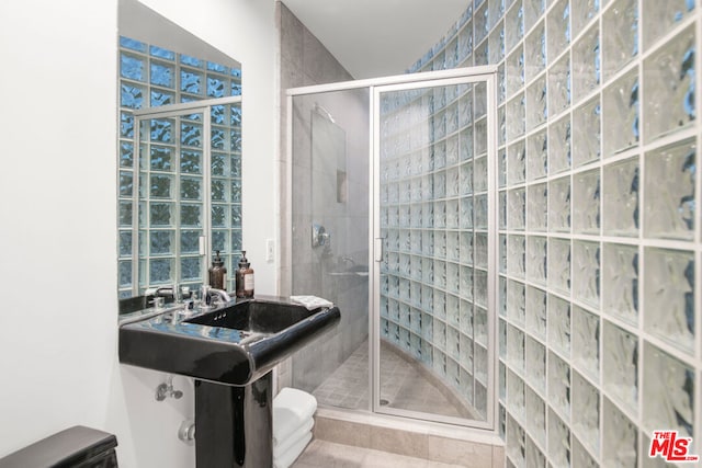 bathroom featuring tile patterned flooring, toilet, and an enclosed shower