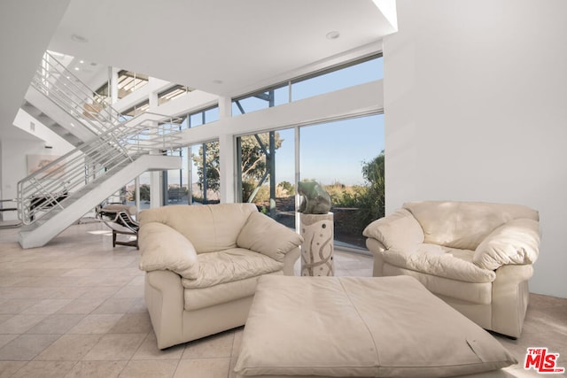 living room with a high ceiling and light tile patterned floors