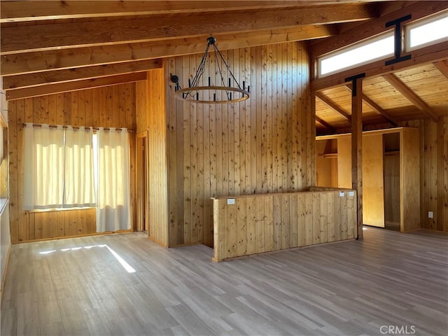 interior space with pendant lighting, wood walls, wooden ceiling, lofted ceiling with beams, and hardwood / wood-style flooring