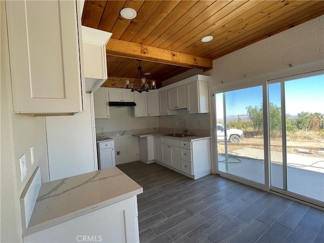 kitchen with light stone counters, wood ceiling, beam ceiling, white cabinets, and dark hardwood / wood-style floors