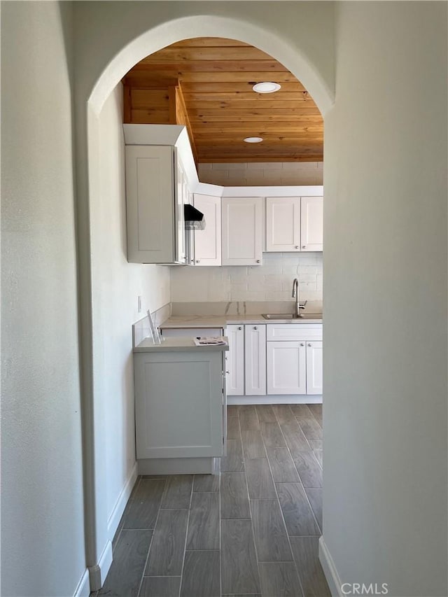 kitchen featuring dark hardwood / wood-style flooring, white cabinetry, sink, and wooden ceiling