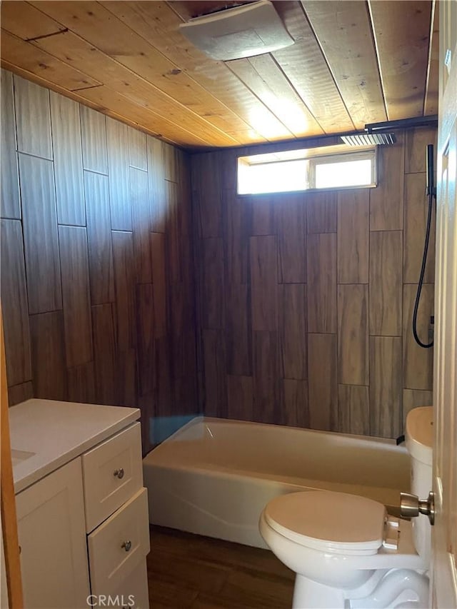 full bathroom featuring wooden ceiling, toilet, wooden walls, vanity, and tiled shower / bath